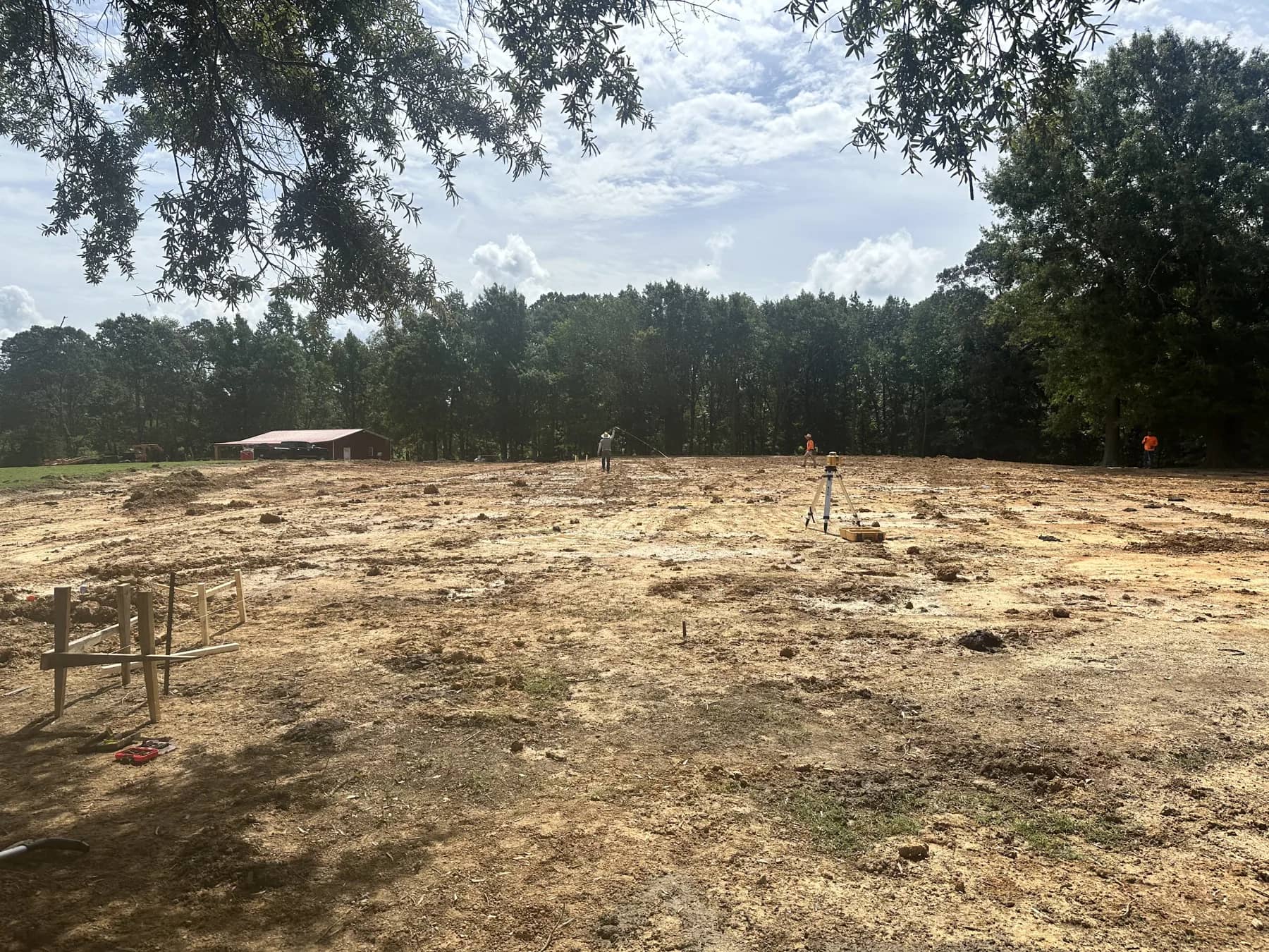 Graded open property bordered by a mature tree line, ready for the next stage of site work
