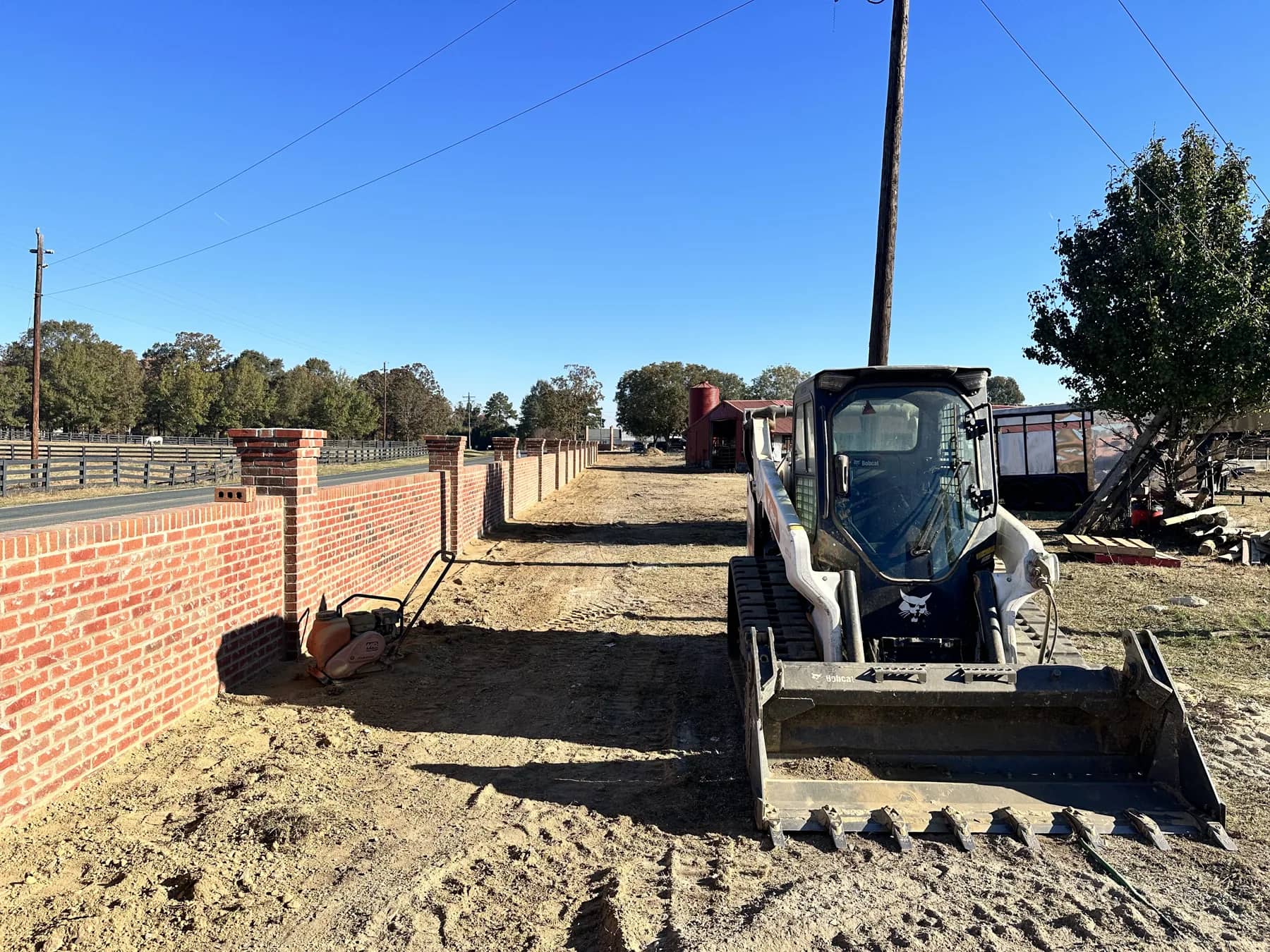 Skid steer on an exposed work site with freshly worked ground